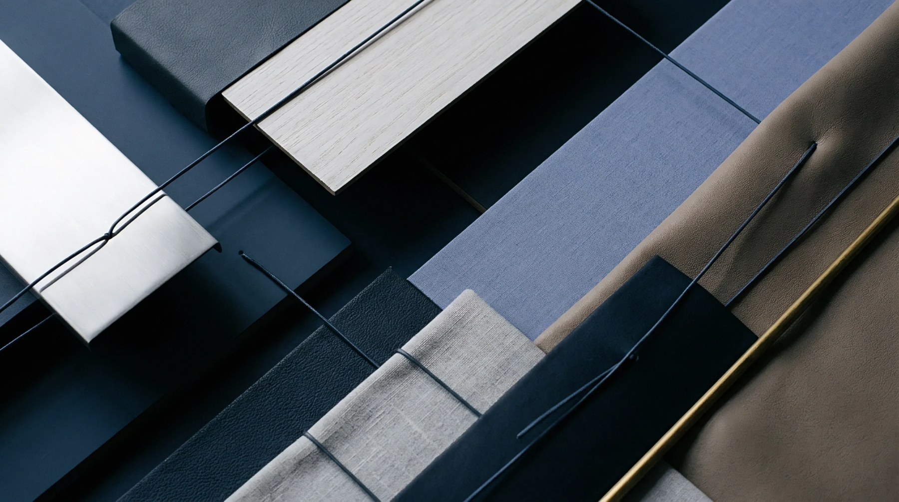 Diverse material samples including woven flax textiles leather panels and wood veneers are arranged across a deep blue production surface.