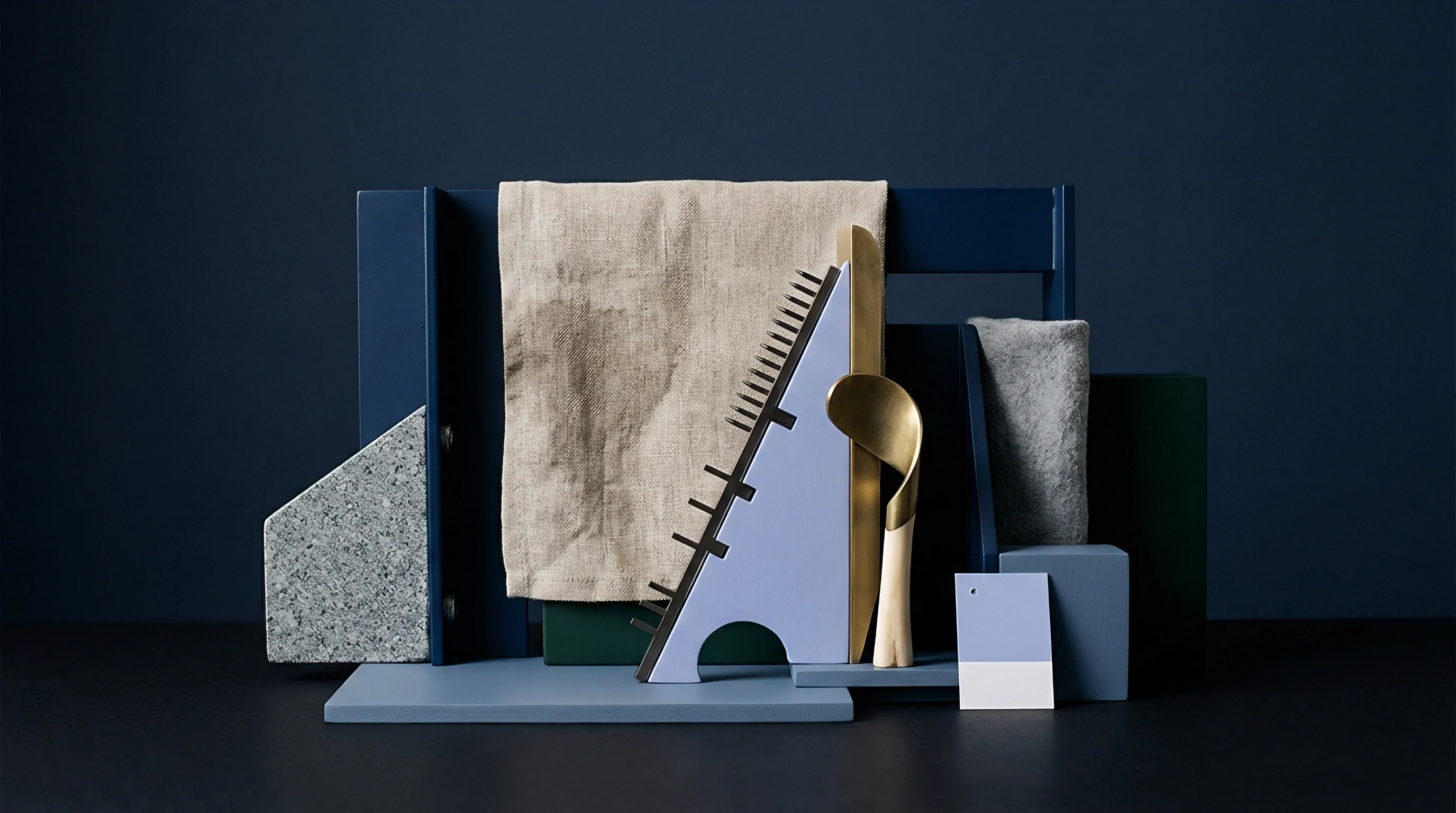 A woven natural fabric sample is artfully arranged with stone, metal, wood, and geometric forms in a dark studio setting.